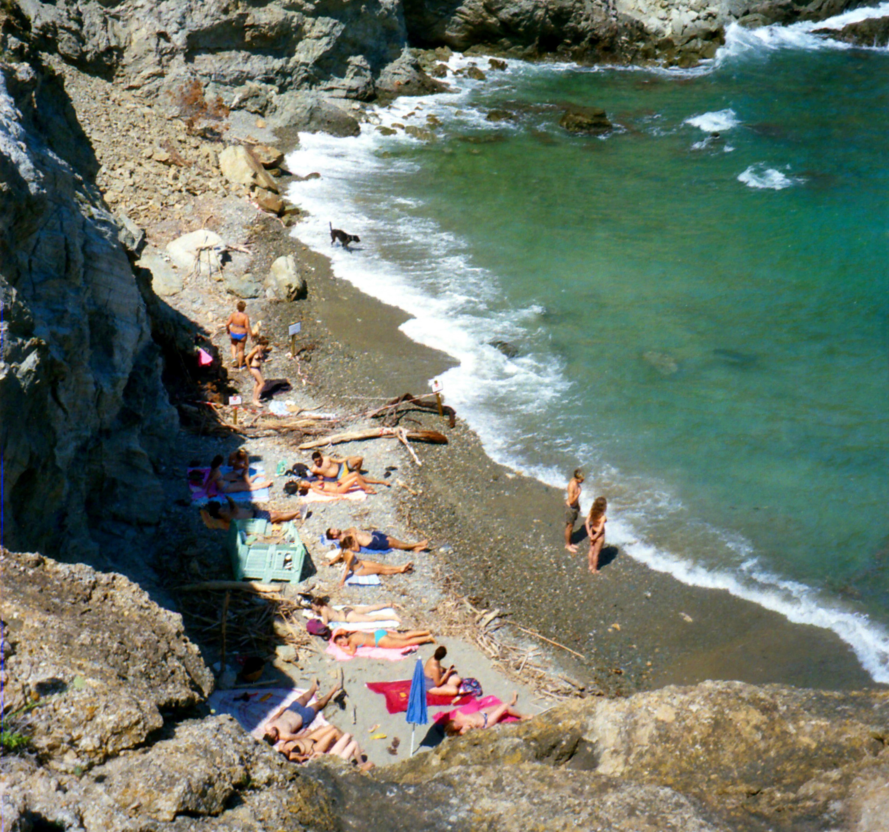 A view from above of people laying on a small beach.