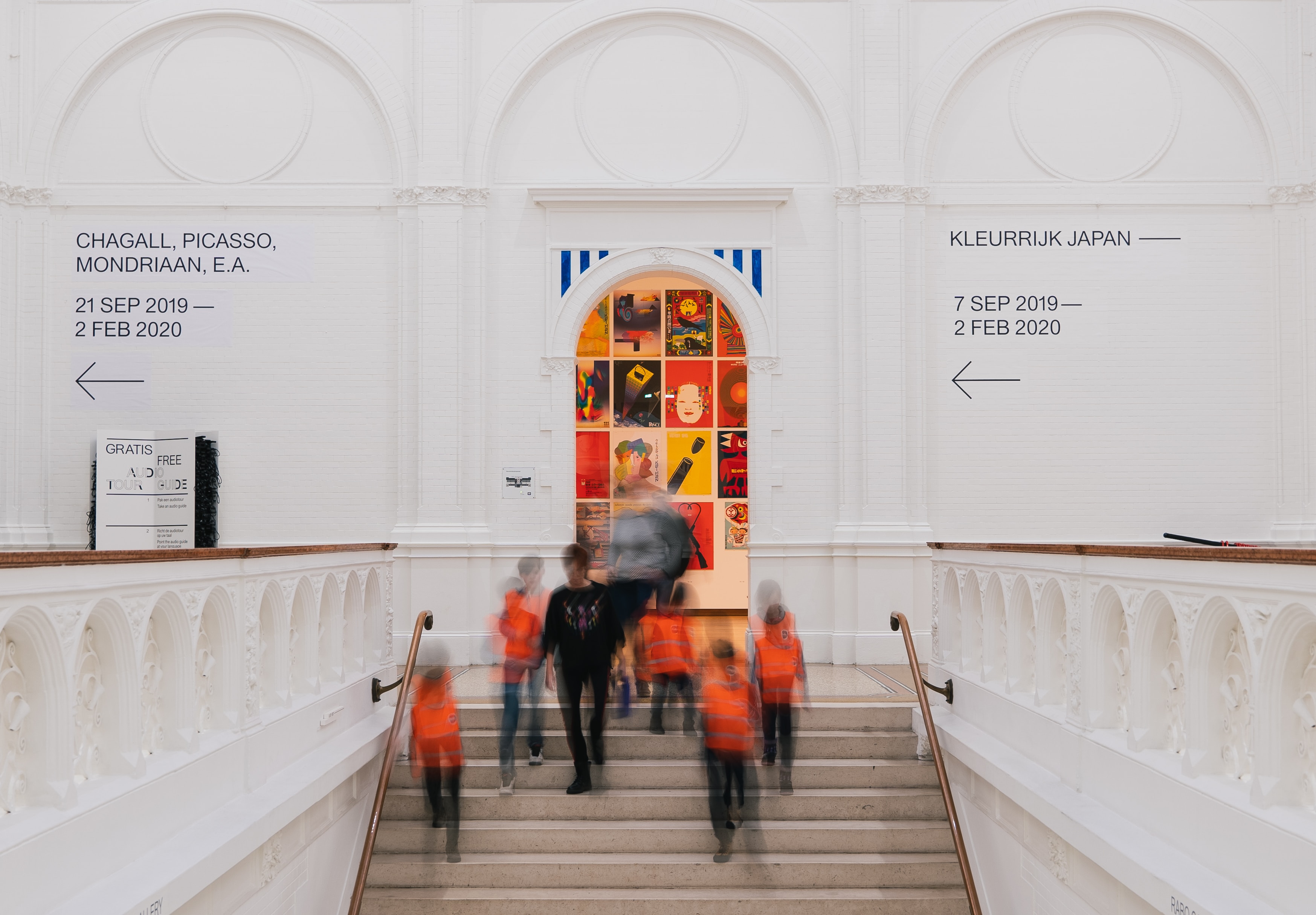 View of museum entrance hall with blurry people walking by.