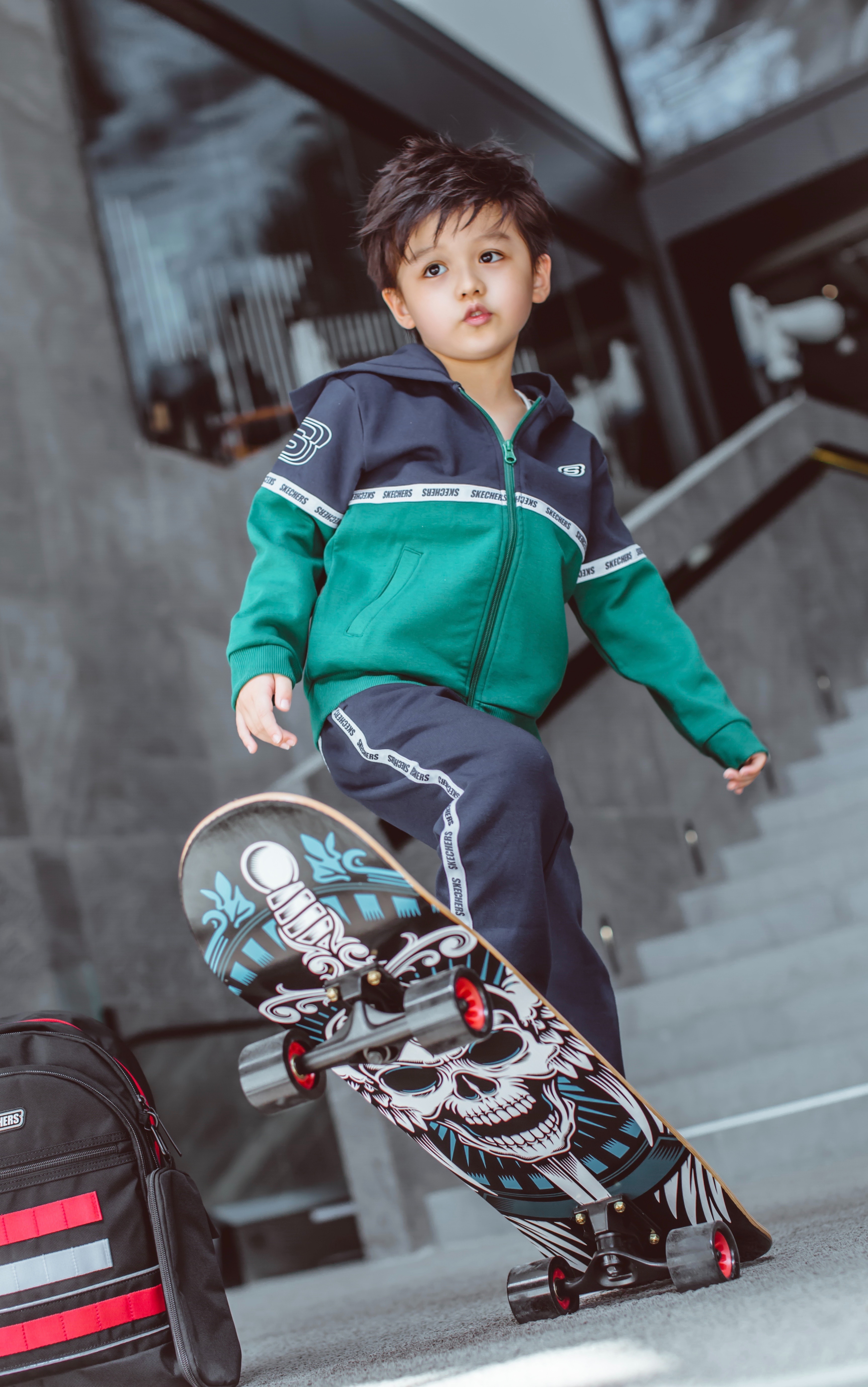 Young boy leans back on skateboard before skating